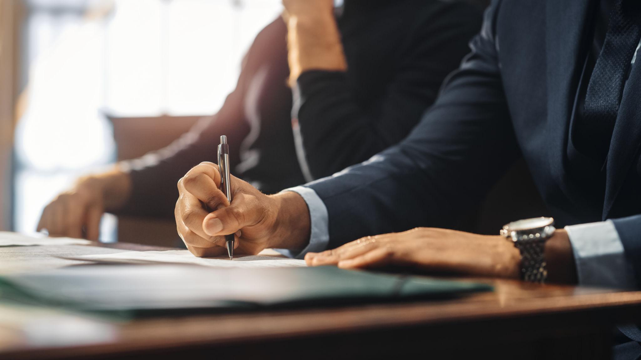 Attorney signing legal documents while planning a defense